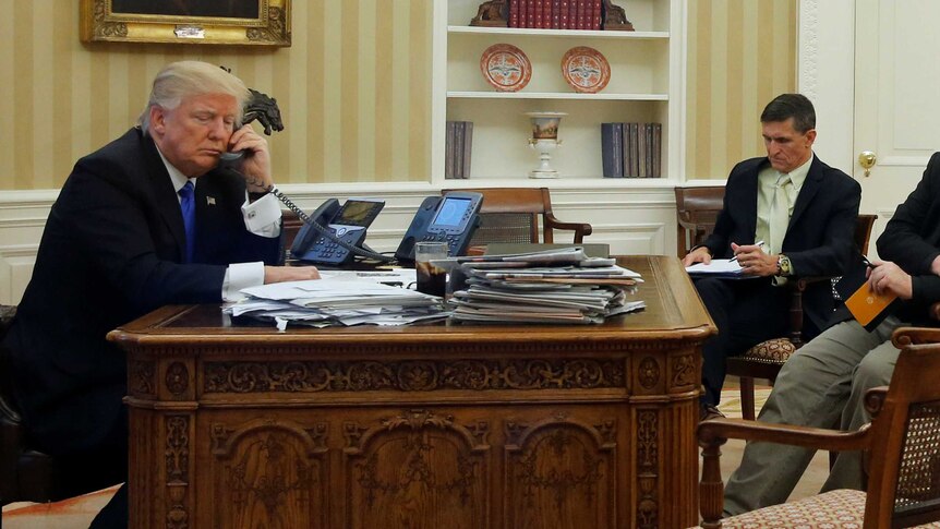 US President Donald Trump (L), seated at his desk in the White House speaks with Australian Prime Minister Malcolm Turnbull.