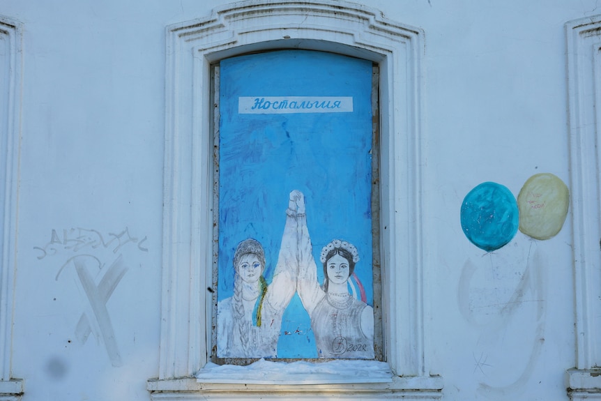 A street art of two women holding hands raised