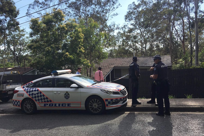 Police officers and cars outside the house in Fig Tree Pocket Road at Chapel Hill.