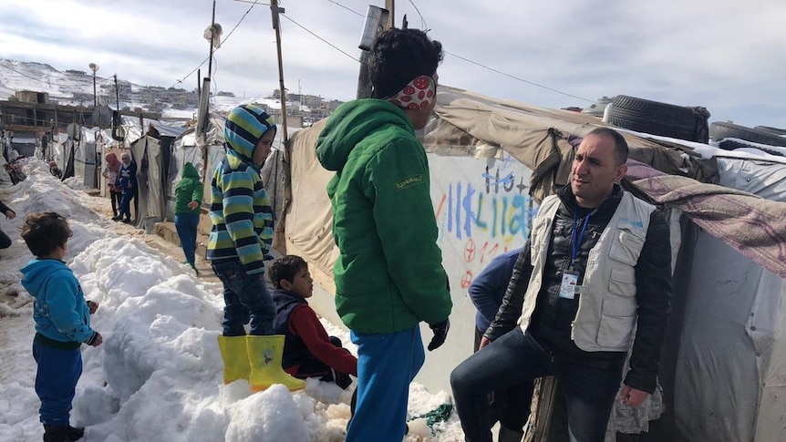 People huddle against the cold in refugee camps in Lebanon covered in snow after record Winter storms