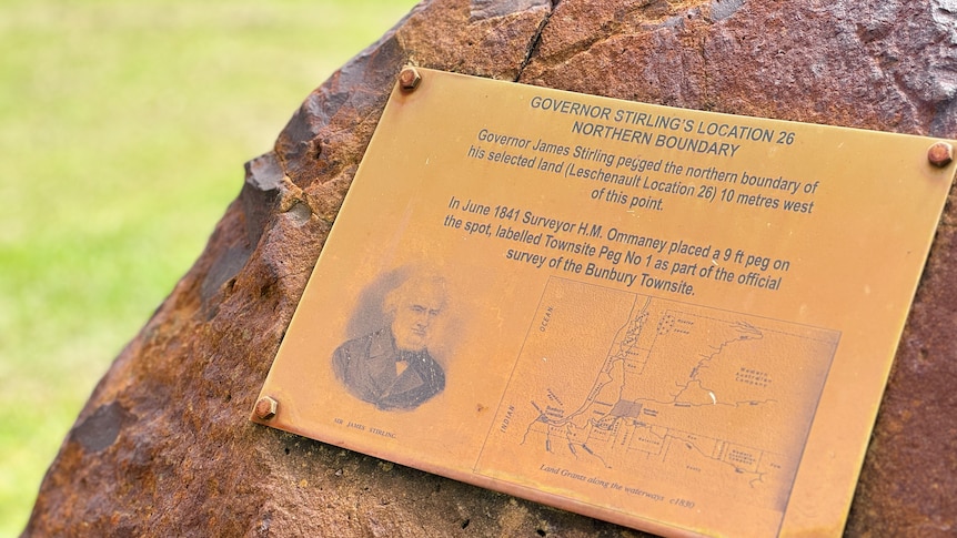 A gold plaque mounted on a rock with text telling the story of the establishment of the Bunbury town site.
