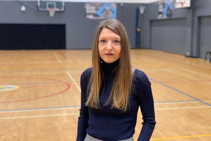 Dr Aurelie Pankowiak poses for a photo on one of the basketball courts at Victoria University