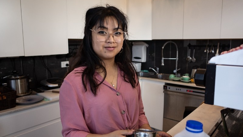 A woman with glasses on in a cafe kitchen.