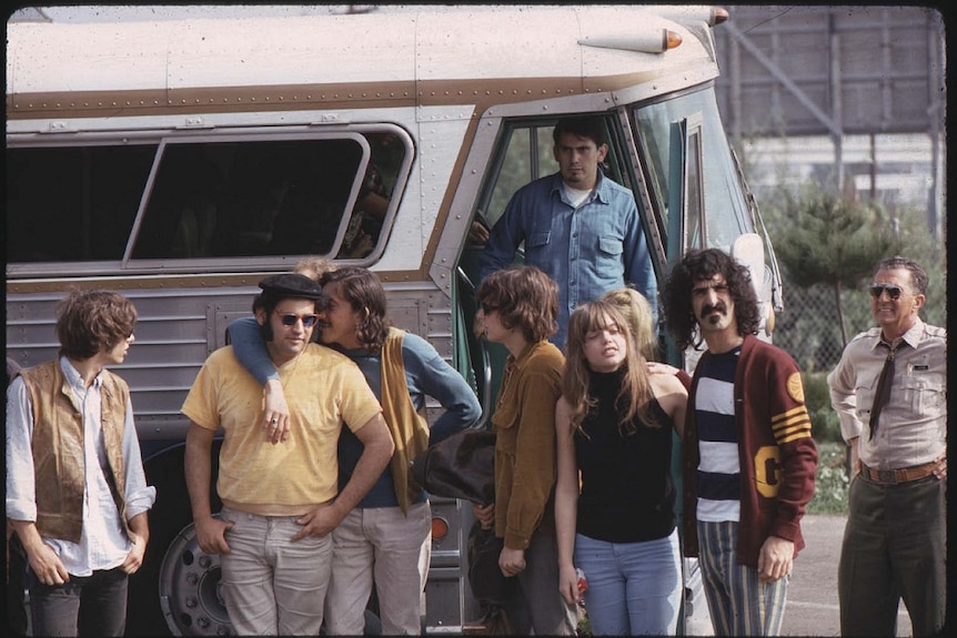 Frank Zappa (far right) and the Mothers of Invention next to a tour bus.