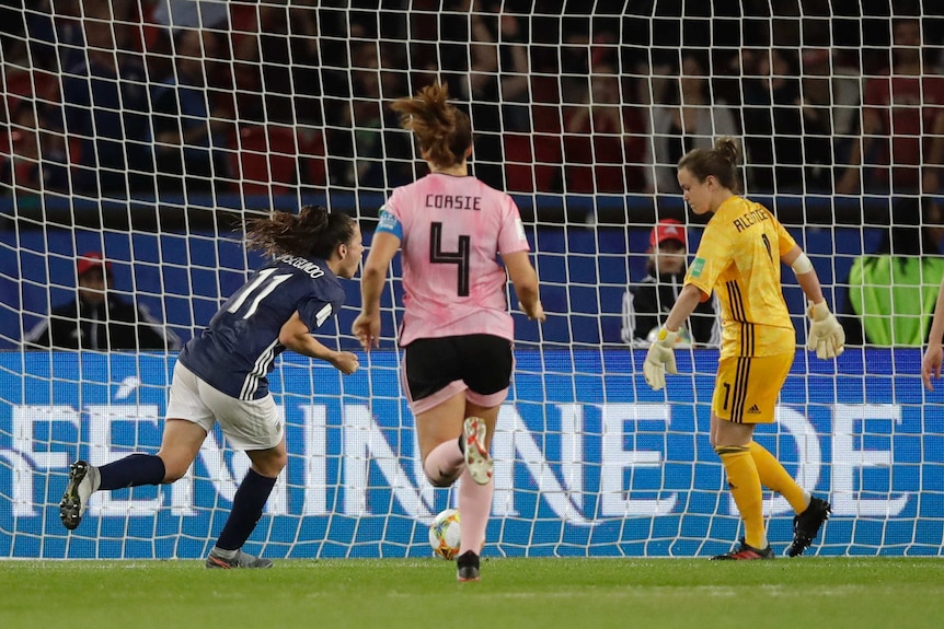 A soccer player wheels away in celebration after scoring a vital penalty at the Women's World Cup.