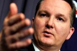 Chris Bowen gestures as he speaks during a press conference