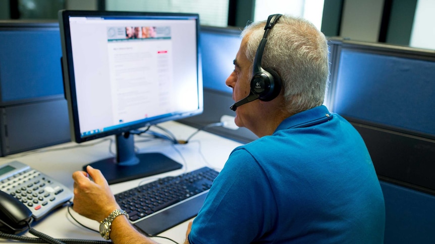 A man on a phone in a call centre