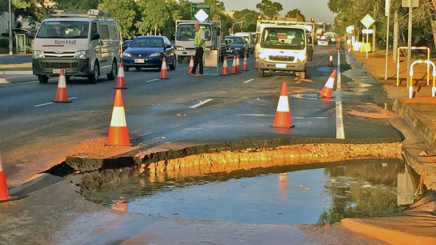 crater in the roadway after a main burst