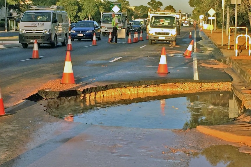 crater in the roadway after a main burst