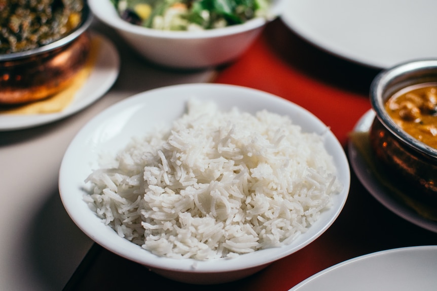 A bowl of white rice on a table. 