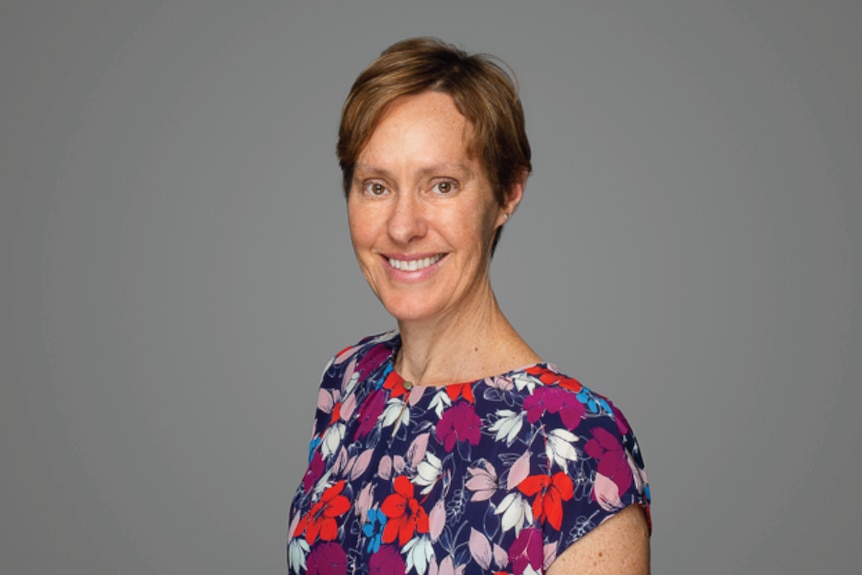 An official photo of Karen Magraith wearing a floral tshirt in front of a grey background