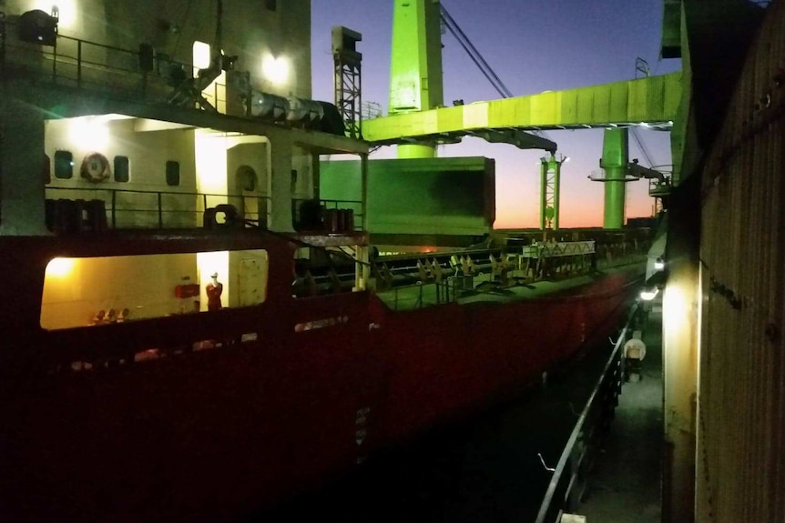 Ship loading mining exports at night.