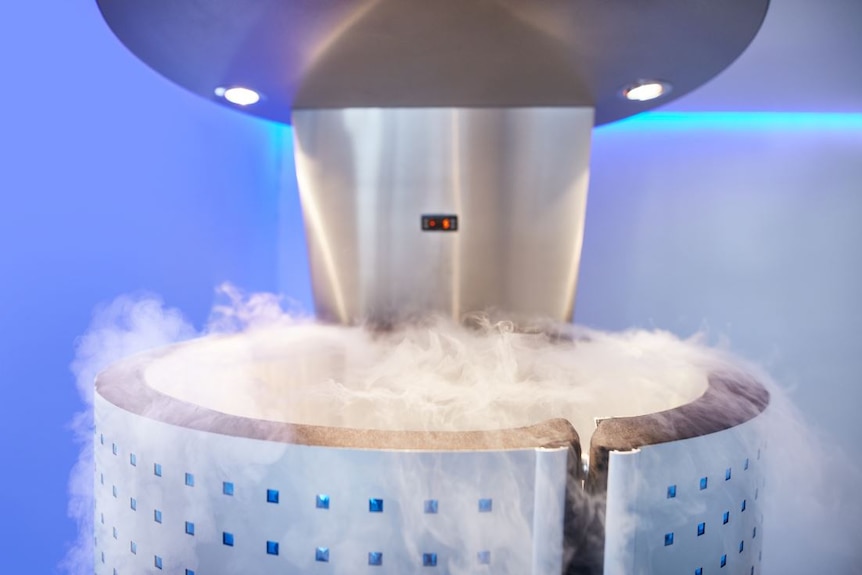 A large metallic chamber, set against a light purple background, with misty smoke bubbling up from the top of it.