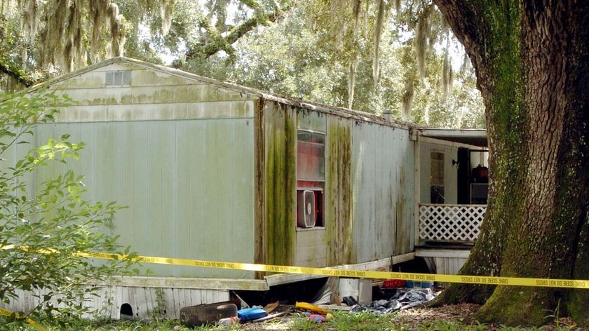 Police tape surrounds the scene in a trailer park where seven people were found dead