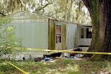 Police tape surrounds the scene in a trailer park where seven people were found dead