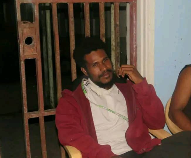 A Papua New Guinean man wearing a maroon jumper 
