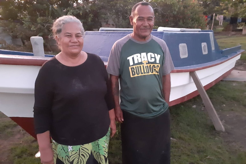 Reverend Toetu'u and his wife pose in front of their fishing boat. 