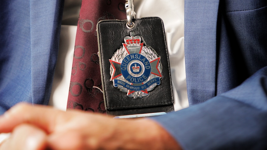 a close-up of a police badge on a lanyard being worn by a detective