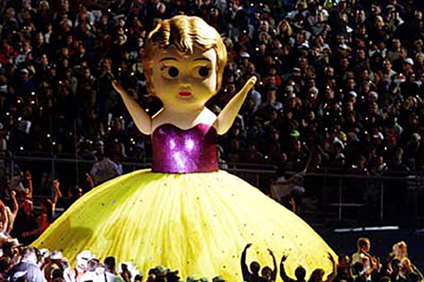 Giant kewpie doll in purple top and yellow skirt at the Sydney Olympics closing ceremony