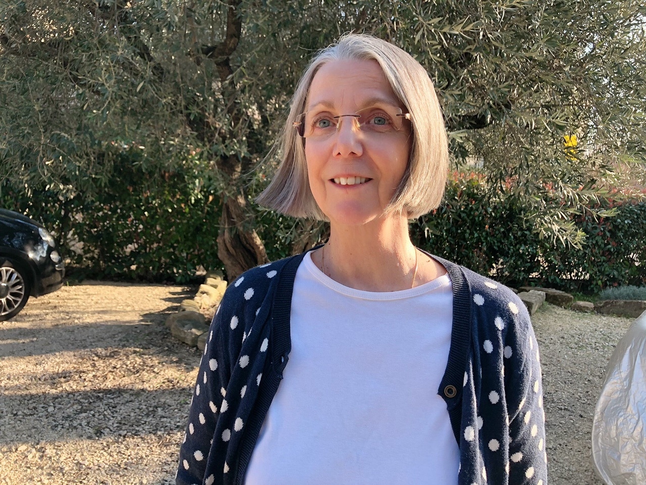 A woman standing in front of a tree.