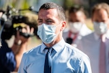 NT police officer Zachary Rolfe outside the NT Supreme Court. He is wearing a blue button-up shirt, a navy tie and a face mask.