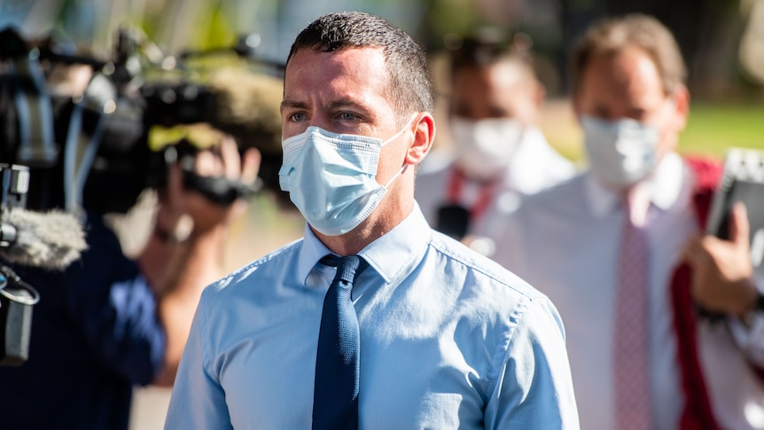 NT police officer Zachary Rolfe outside the NT Supreme Court. He is wearing a blue button-up shirt, a navy tie and a face mask.