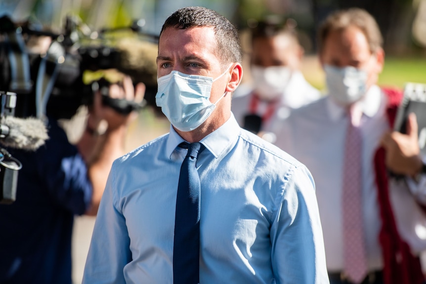 NT police officer Zachary Rolfe outside the NT Supreme Court. He is wearing a blue button-up shirt, a navy tie and a face mask.