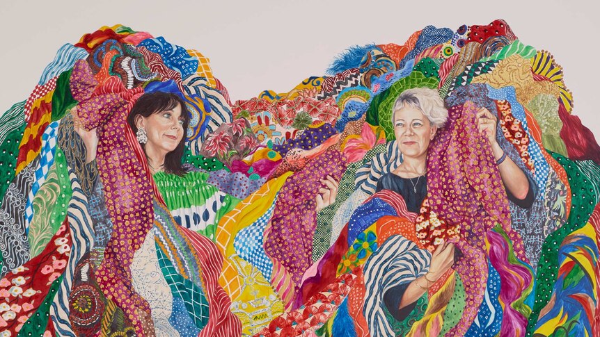 An oil on board painting of two women wrapped in a mass of colourful fabrics.