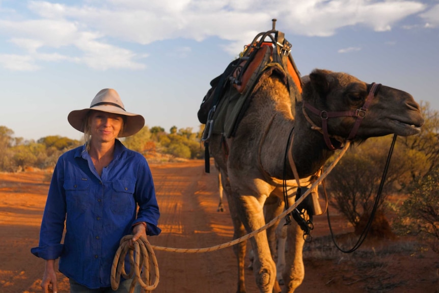 Sophie Matterson leading her team of camels through outback terrain at Wooleen Station in the Murchison.