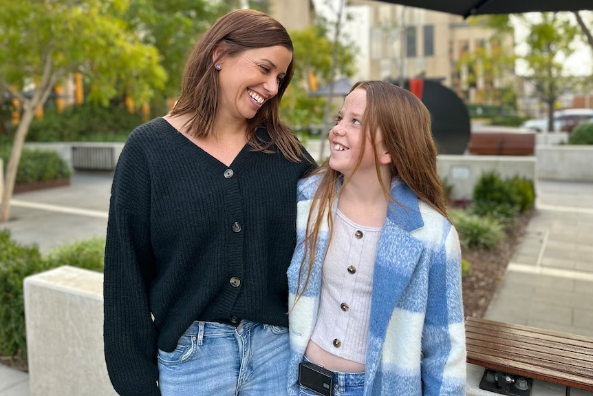 A mum and daughter smiling at each other.