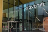 The Novotel hotel hotel in Melbourne, South Wharf, as a police officer walks towards the entrance.