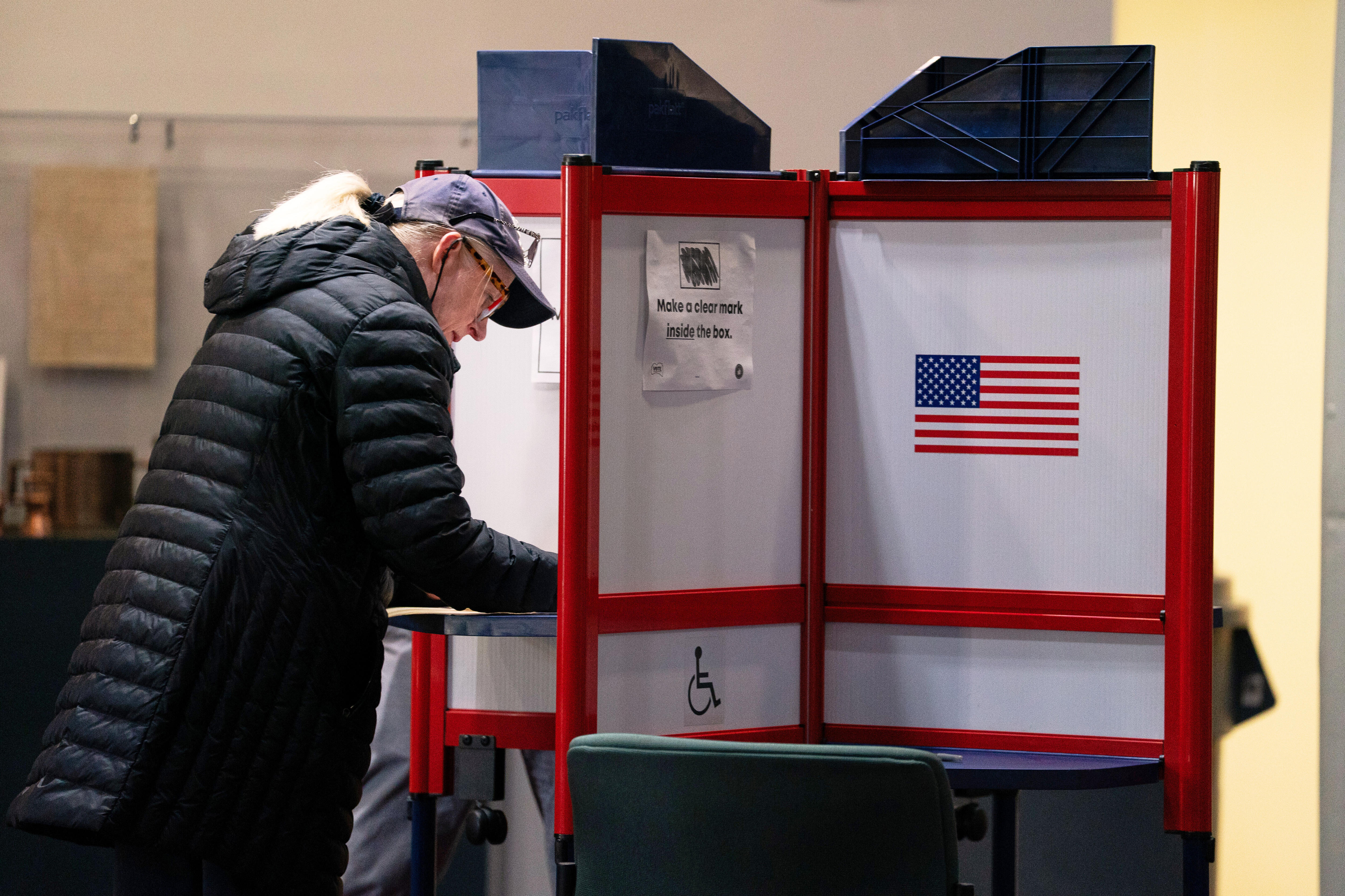 A woman filling out her ballot at a polling station.