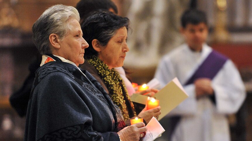 Ireland's Marie Collins (left) holds a candle at a mass in Rome.