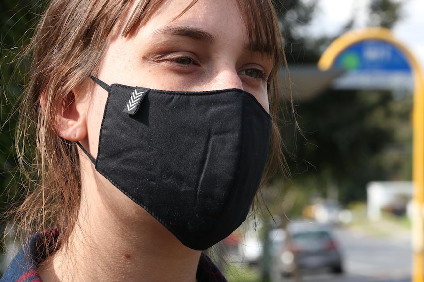 A young woman wearing a mask. 