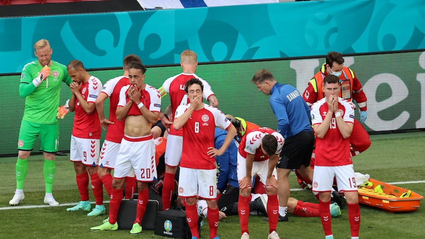 Denmark's players react as their teammate Christian Eriksen lays injured on the ground