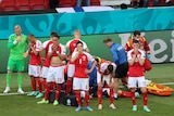 Denmark's players react as their teammate Christian Eriksen lays injured on the ground