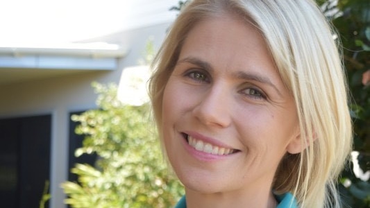 A woman in a polo shirt smiles