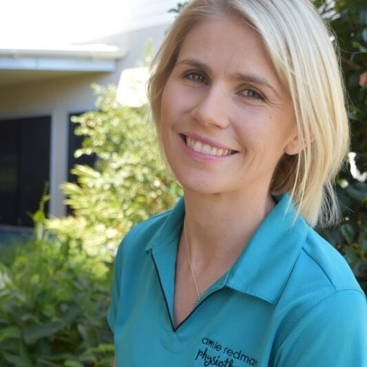 A woman in a polo shirt smiles