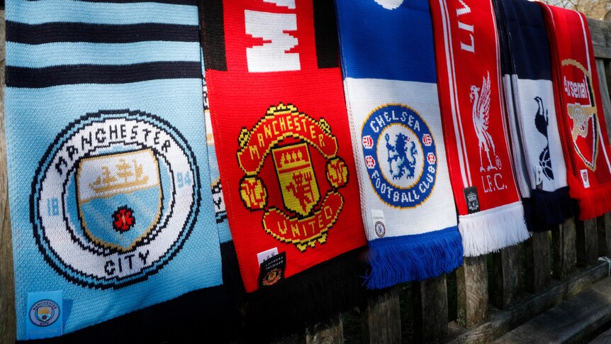 Scarves of Manchester City, Manchester United, Chelsea, Liverpool, Tottenham and Arsenal hang side by side.