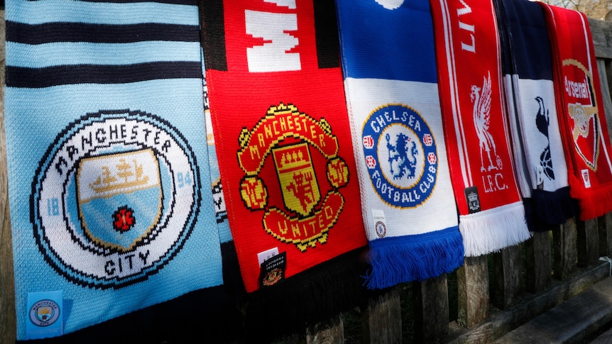 Scarves of Manchester City, Manchester United, Chelsea, Liverpool, Tottenham and Arsenal hang side by side.