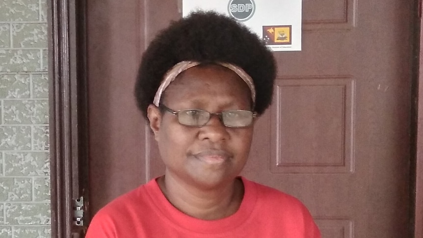 Head-shot of a Papua New Guinean woman in a red shirt