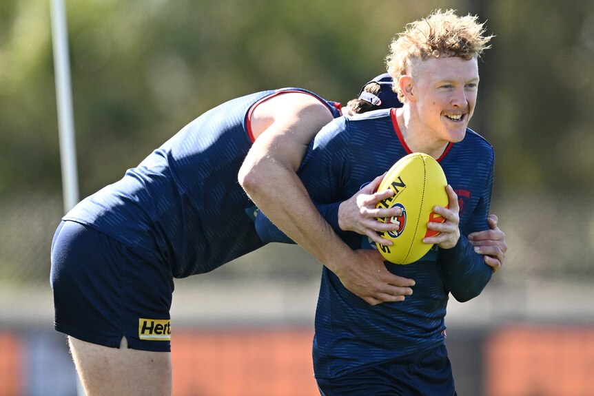Clayton Oliver smiles as he is tackled in training