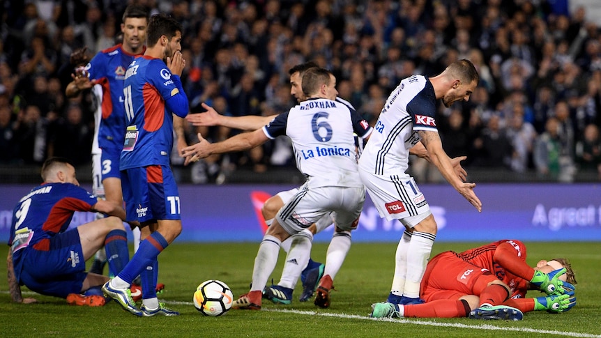 Melbourne Victory players check on stricken Lawrence Thomas