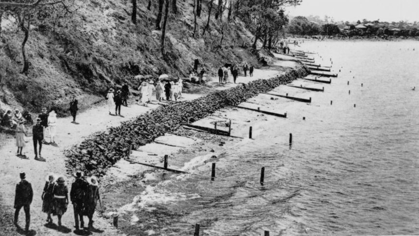 People walking along a bay.