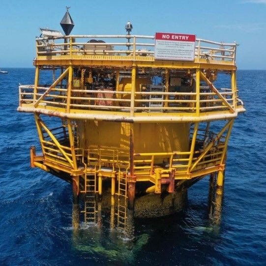 A yellow steel structure is in the ocean.