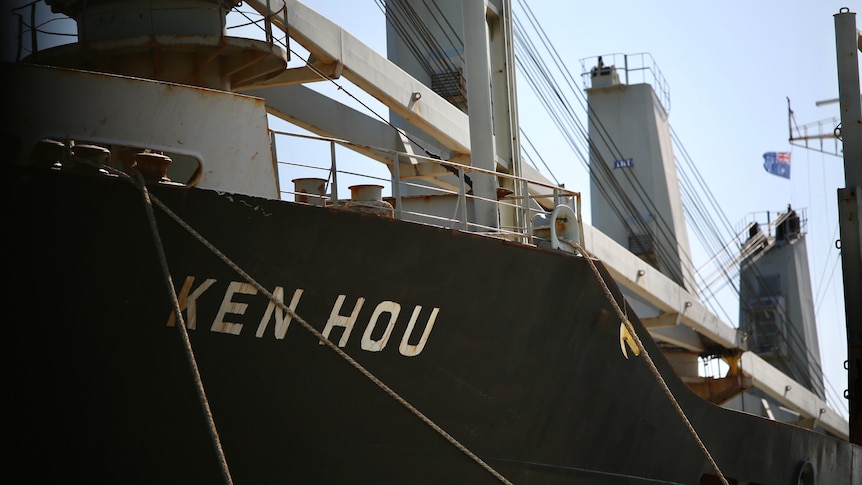 The prow of the ship in dock. The name Ken Hou is written on the prow.