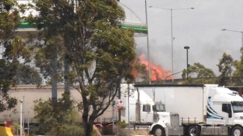 Flames burning behind a petrol station at the Epping grassfire