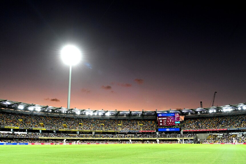 The sun sets over the Gabba during the cricket