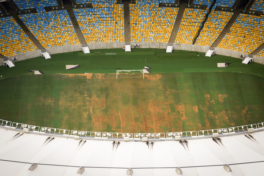 A bird's eye view of a stadium with dying grass 