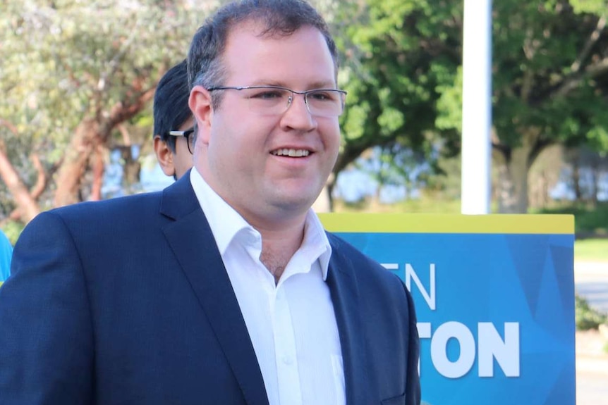 Liberal Party candidate for Tangney Ben Morton stands in front of supporters with placards.